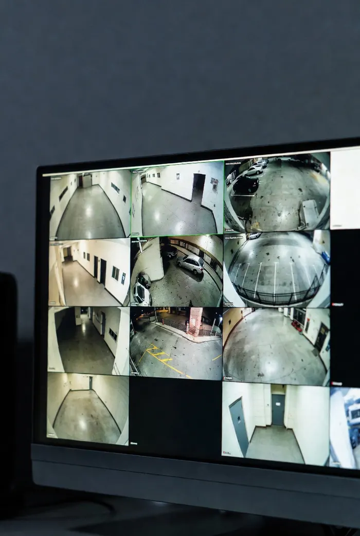 CCTV monitor showing a multi-camera live view of corridors and a car park
